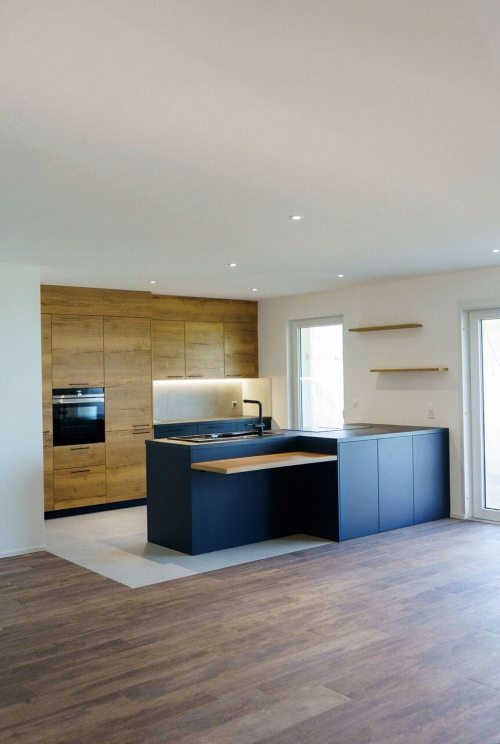 une cuisine moderne avec des armoires bleues et un îlot / a modern kitchen with blue cabinets and an island