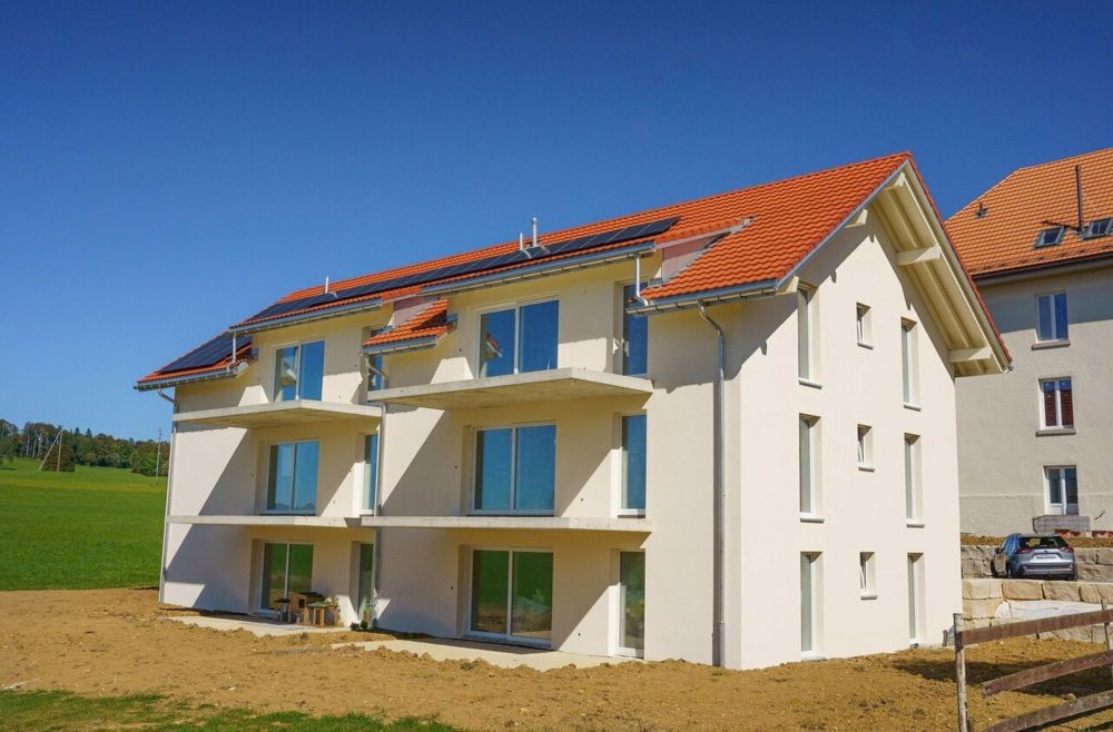 une maison blanche avec des panneaux solaires sur le toit / a white house with solar panels on the roof